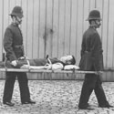 Policemen carrying a man on a stretcher, 1884. Catalogue reference: Image reference: COPY 1/369