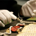 A gloved pair of hands handling a document
