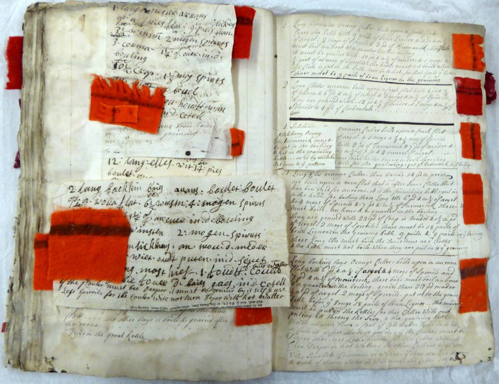 A dyeing recipe book from the 1720s with handwriting and small fragments of textile