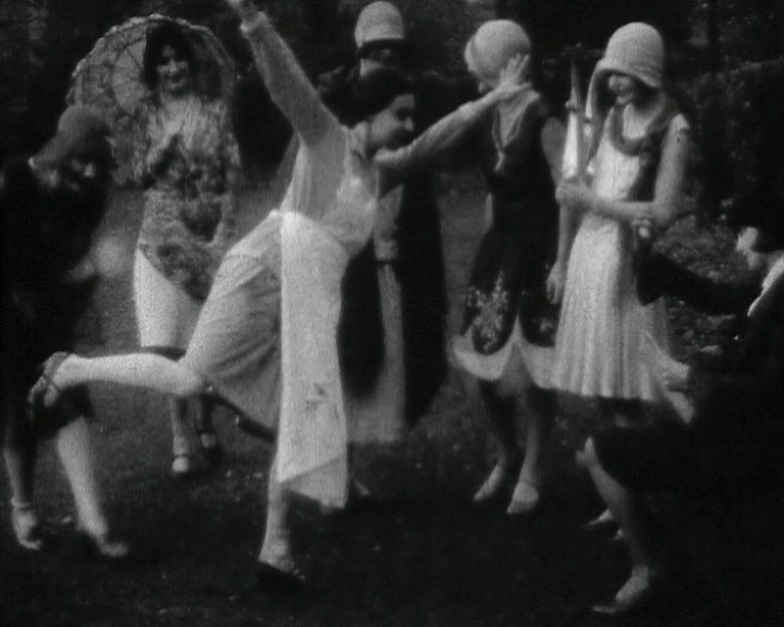 A still from black and white footage of a group of early 1900s women dancing