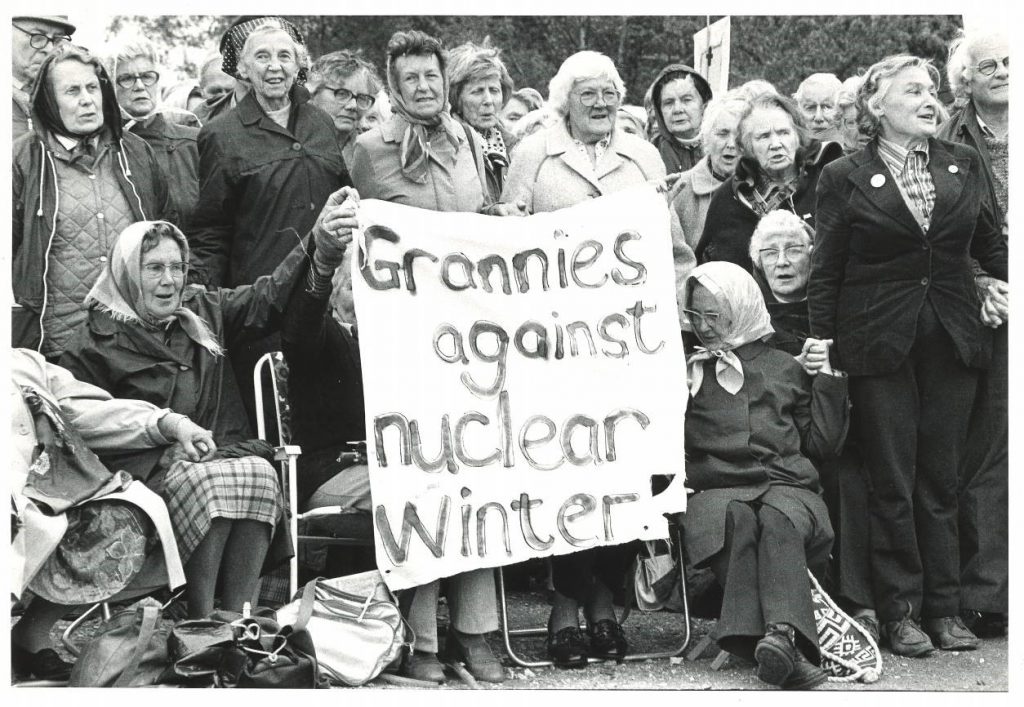 A black and white photograph of older woman holding a banner saying 'Grannies against nuclear winter'