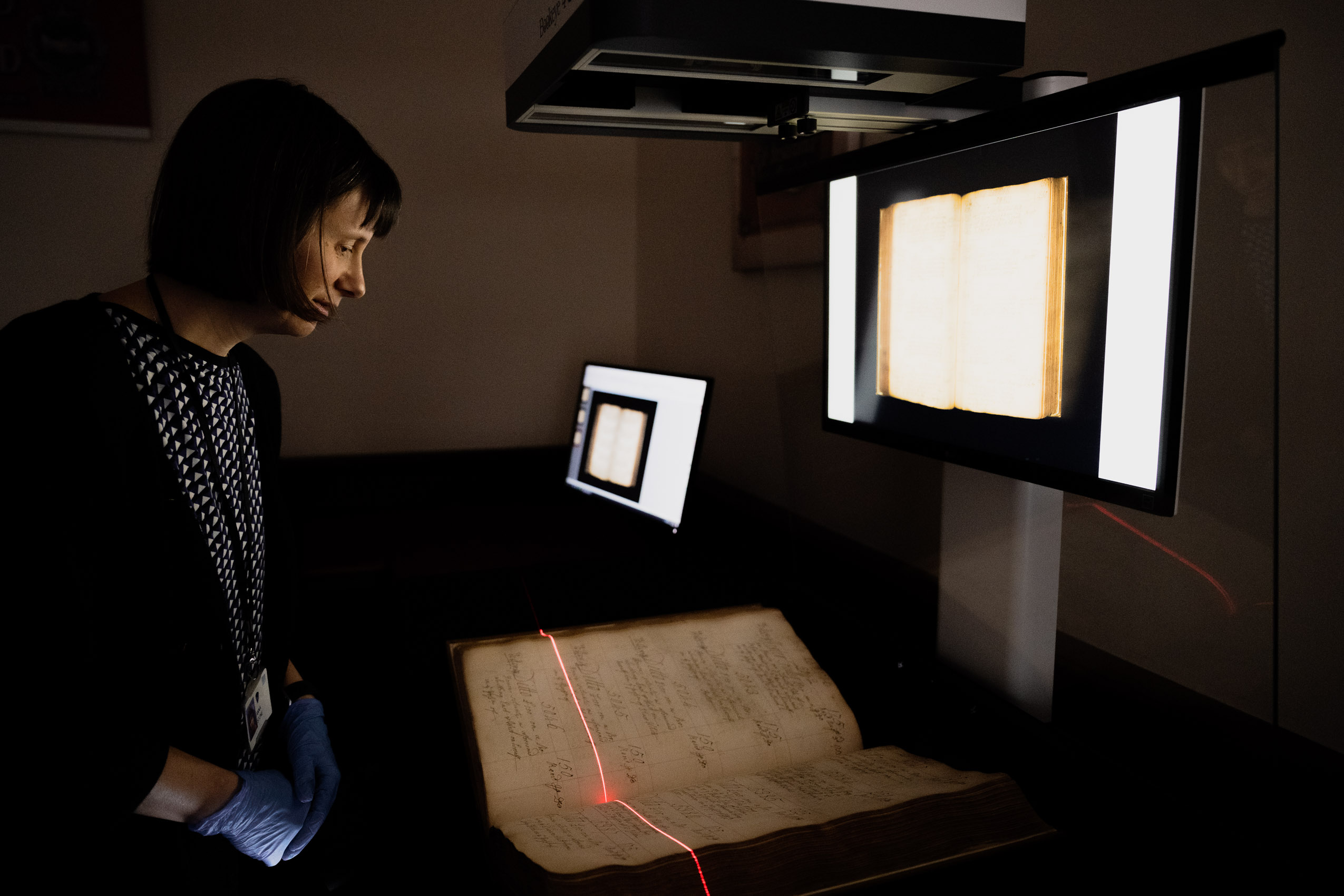 A woman digitising a large old book