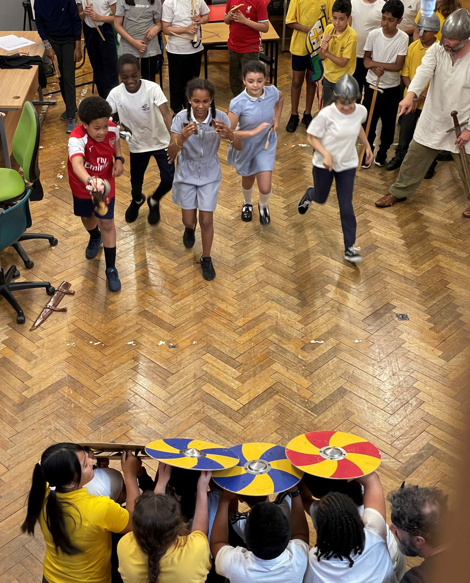 School children dressed up and re-enacting a battle in a hall