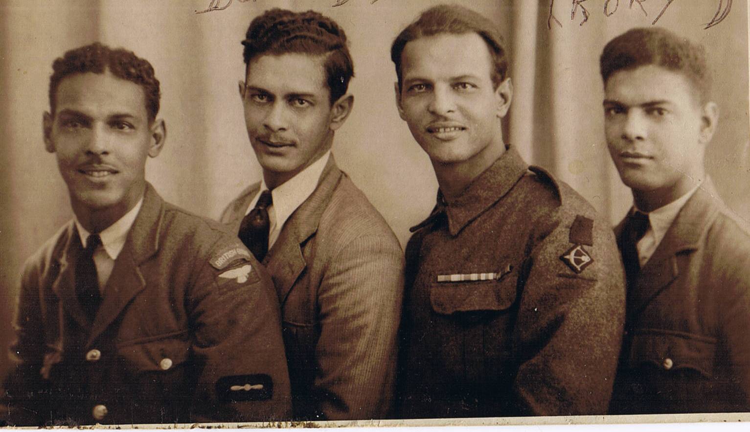 A sepia photograph of four men in uniform