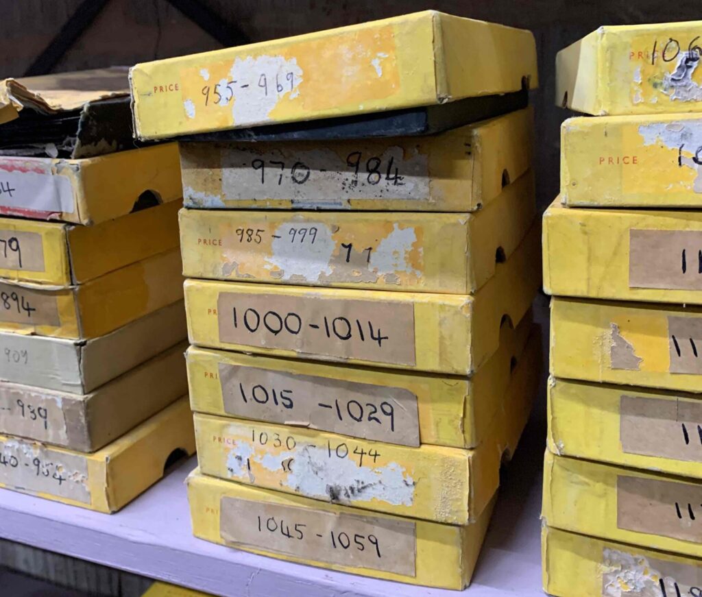 A number of worn yellow A4-size slim boxes.