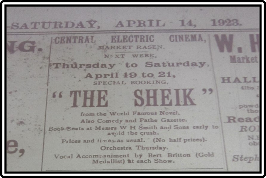 An advert for "The Sheik" film in the local paper, in purple printed font on beige background.